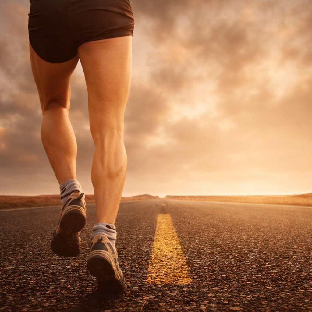 ขาของนักวิ่งบนถนนยางมะตอยสะท้อนถึงความมุ่งมั่นในการซ้อม